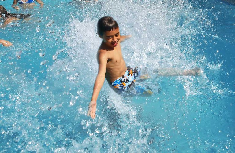 Junge springt ins Schwimmbecken